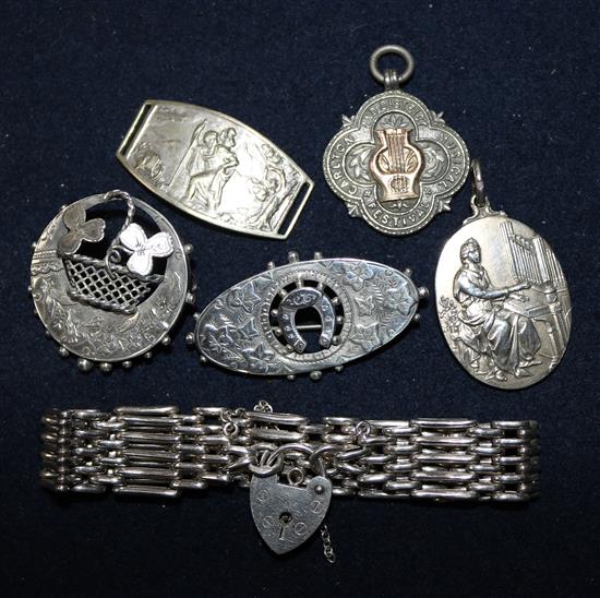 A silver gatelink bracelet, two Victorian silver brooches, two silver medallions and a French plated buckle.